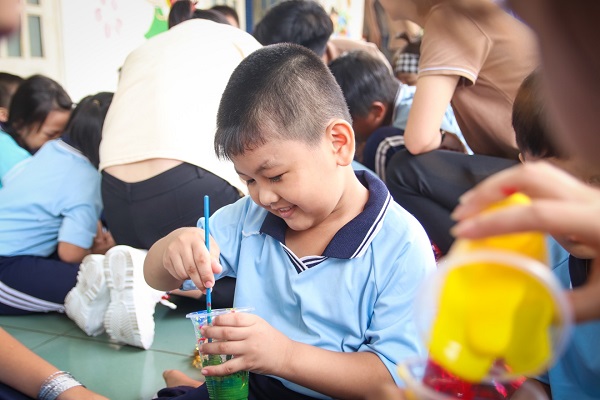 Một bạn nhỏ đang pha màu để trang trí lồng đèn